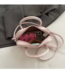 Vue de dessus montrant l'intérieur spacieux du sac polochon rose avec des essentiels