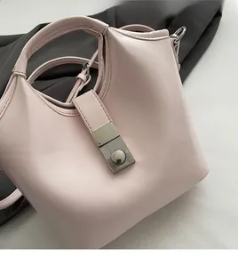 Detailed view of pink leather handbag featuring a silver metal buckle and soft texture