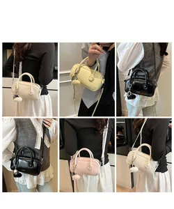 Vues détaillées du mini sac Boston avec bandoulière en dentelle et breloque cœur colorée
