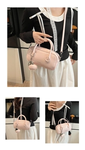 Détail du sac Boston rose montrant la texture brillante, le cœur argenté et la bandoulière