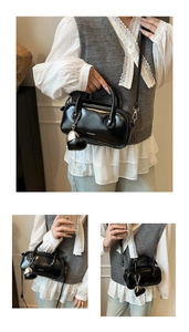 Détail du sac polochon noir brillant avec doubles poignées et breloque en cœur