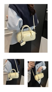 Détail d'un sac polochon beige avec texture cuir et pendentif en forme de cœur