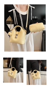 Detalle del bolso tipo cubo crema con herrajes plateados y correa de hombro ajustable