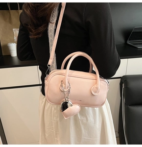 Sac à main boston rose avec pendentif cœur argenté et bandoulière amovible sur modèle