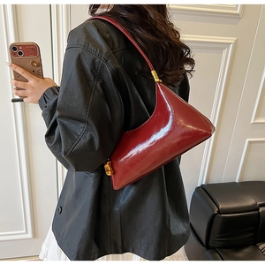 Detailansicht der weinroten Lackleder-Schultertasche mit goldener Metallschnalle