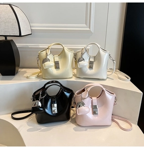 Detail view of four glossy leather bucket bags in cream, white, black, and pink colors