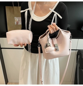 Detalle de set de bolsos tipo cubo rosa claro con cierre plateado y dije de corazón