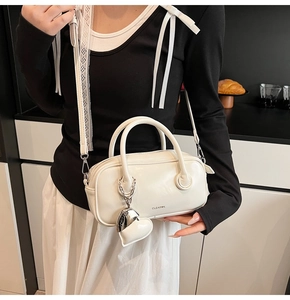 Close-up of white glossy small square handbag with heart pendant and CLEAR❤K brand logo