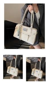 Detail of cream white tote bag with metal logo plate, zipper pocket and bear charm