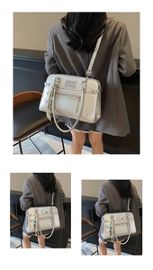 Detail of silver metallic hobo bag featuring zipper pockets and adjustable straps