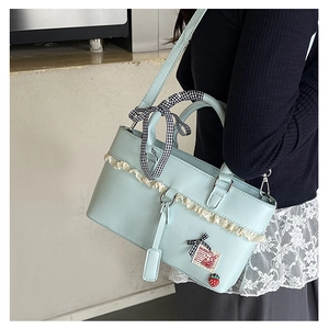 Detailed shot of mint green crossbody bag featuring white lace trim and ribbon detail