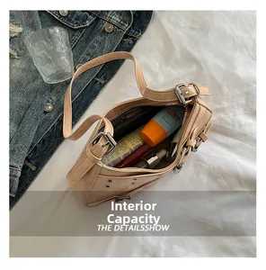 Capacité interne du sac à bandoulière en similicuir beige avec boucle argentée
