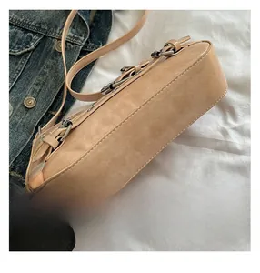 Détail du sac en cuir beige mat avec boucle en métal argenté et coutures précises