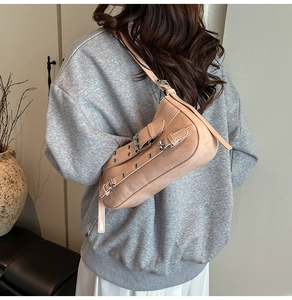 Détails d'un sac baguette chic en similicuir abricot avec boucles argentées et rivets