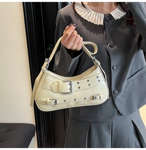 Détail du sac crème avec boucles argentées et clous métalliques au style Y2K chic