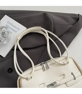 Close-up of white leather handbag straps and metal zipper on grey blazer background