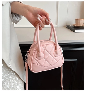 Detail of pink quilted handbag with diamond stitching and elegant top handles