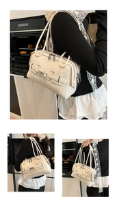 Detail of cream white PU shoulder bag with silver metallic hardware and zippers