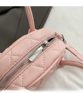 Close-up of durable metal zipper and quilted diamond pattern on pink boston bag