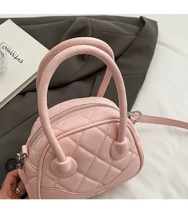 Close-up of pink quilted leather Boston bag with soft handles and silver metallic hardware