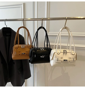 Detailed view of fashionable underarm bags in brown, black, and beige with metal buckles