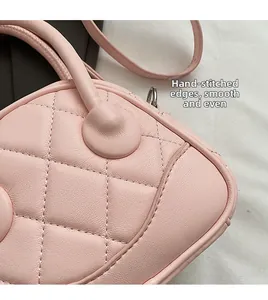 Detailed close-up of quilted diamond pattern and stitching on light pink leather handbag