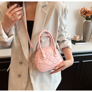 Pink quilted leather mini Boston bag shown with elegant outfit and crossbody strap