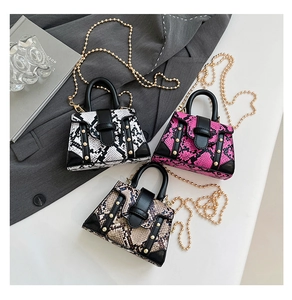 Detailed view of snake skin mini bags with gold chains and elegant metallic accents