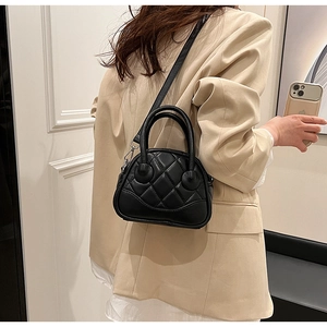 Quilted black crossbody bag styled with a beige blazer for a modern casual look