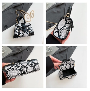 Detail view showing snake skin texture, golden studs, and chain strap on the crossbody bag