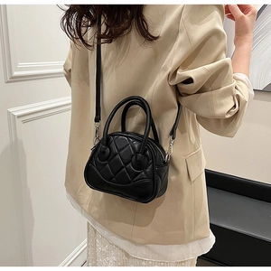 Detail of black quilted leather Boston bag featuring a unique smiley face stitching design