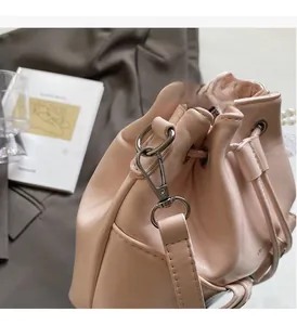 Détail du sac seau en cuir rose avec des ferrures métalliques argentées brillantes