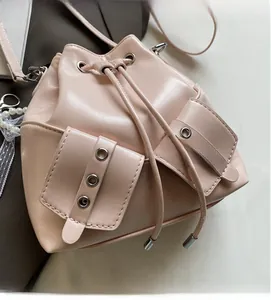 Détail du sac seau en cuir rose montrant la texture plissée et les œillets en argent