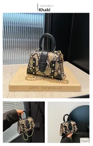 Close-up of khaki faux snake skin mini bag featuring gold studs and metal bead chain