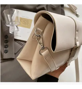 Close-up of cream white waxed leather shoulder bag featuring textured finish and silver hardware