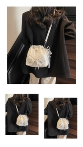 Détail du sac seau crème plissé avec cordon et nœud décoratif en perles et dentelle