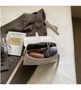 Spacious interior of white leather shoulder bag holding phone, wallet and umbrella