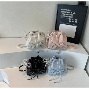 Vue détaillée de quatre mini sacs seaux colorés avec nœuds en perles et cordon de serrage