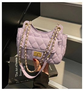 Close-up of lavender quilted handbag with golden twist lock and chain strap detail