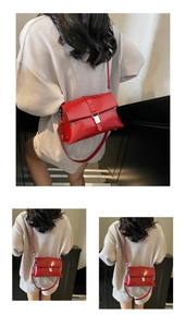 Detail of red leather shoulder bag with silver metal buckle and minimalist strap