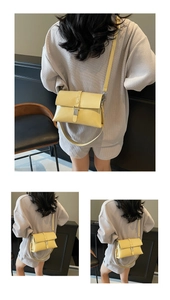 Detail showing the lemon yellow oil wax leather texture and adjustable strap on the bag