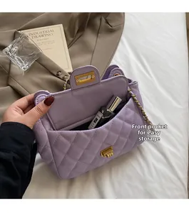 Detail of purple quilted chain bag with front pocket and gold twist lock closure