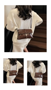 Detail of vintage dark brown polished leather shoulder bag with silver buckle and strap