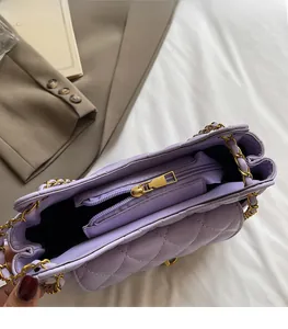 Detail of purple quilted chain bag interior featuring gold hardware and smooth zipper