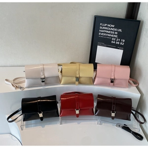 Selection of colorful minimalist shoulder bags with silver buckles in a tiered display