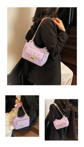 Close-up of light purple quilted chain bag with gold twist lock and diamond stitching
