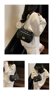 Detailed view of black quilted PU shoulder bag with gold rotating lock and chain strap