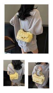 Detailed close-up of cream quilted chain underarm bag with elegant metal twist lock