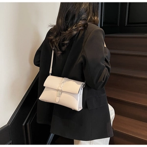 Chic cream white oil wax leather shoulder bag with sleek silver metal lock on a model