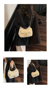 Detail view of a white quilted leather chain bag featuring a gold square turn-lock closure